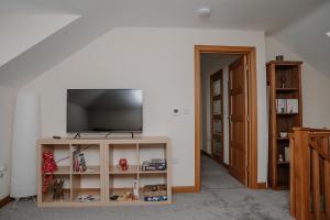 a living room with a flat screen tv on a shelf at Lovely new 1 bedroom loft apartment with on drive parking in Trowbridge