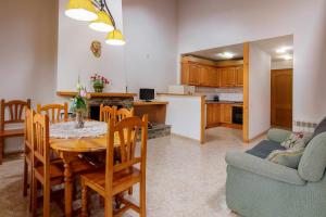 eine Küche und ein Wohnzimmer mit einem Tisch und einem Sofa in der Unterkunft Casa Xaupi 1 in Roní