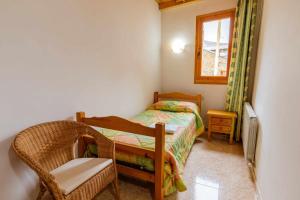 ein kleines Schlafzimmer mit einem Bett und einem Stuhl in der Unterkunft Casa Xaupi 1 in Roní