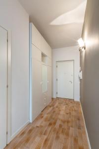 Habitación vacía con paredes blancas y suelo de madera. en Pao Apartment - Navigatori en Verona