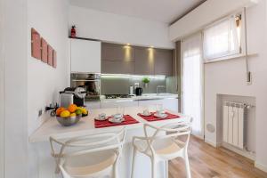 a kitchen with a counter with two chairs and a table at Pao Apartment - Navigatori in Verona