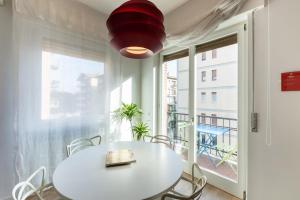 Pao Apartment - Navigatori في فيرونا: طاولة بيضاء وكراسي في غرفة مع نافذة كبيرة