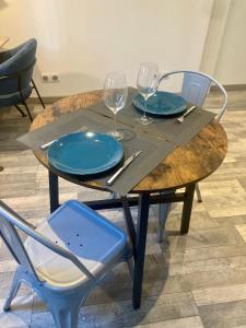 - une table en bois avec 2 assiettes et des verres à vin dans l'établissement Le Foch, à Châlons-en-Champagne