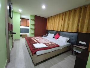 1 dormitorio con 1 cama grande y paredes rojas y verdes en Hotel La Casa, en Namchi