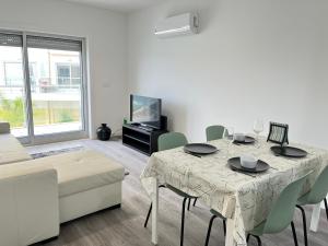 a white living room with a table and a couch at Cliffs Apartment - Astonishing view over Sesimbra bay by Trip2Portugal in Sesimbra