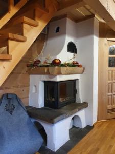a fireplace in a living room with a staircase at Domek Góralski Chatka Puchatka in Poronin +25 photos