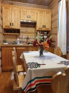 a kitchen with a table with a vase of flowers on it at Domek Góralski Chatka Puchatka in Poronin