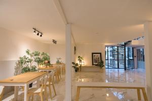 a dining room with wooden tables and chairs at Nap77 Salaya in Salaya