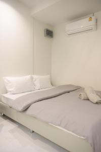 Camera bianca con letto con lenzuola e cuscini bianchi di Nap77 Salaya a Salaya