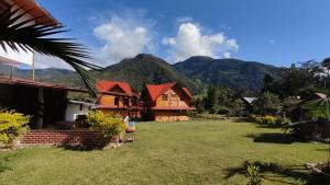 a house with a yard with mountains in the background at Elfen hospedaje familiar in Oxapampa