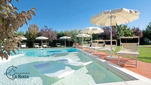 a swimming pool with chairs and umbrellas at B & B La Rotta in Ravenna