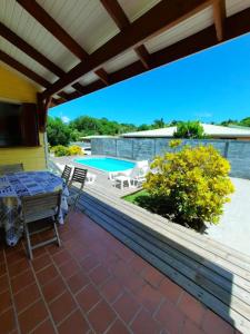 a patio with a table and chairs and a pool at Villa de 2 chambres avec piscine privee jardin clos et wifi a Le Marin a 1 km de la plage in Le Marin
