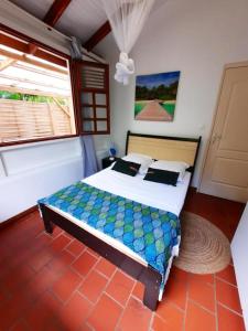 a bedroom with a bed in a room with a window at Villa de 2 chambres avec piscine privee jardin clos et wifi a Le Marin a 1 km de la plage in Le Marin