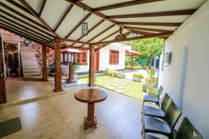 Heritage villa polonnaruwa في بولوناروا: فناء مع طاولة وكراسي خشبية