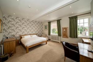 a bedroom with a bed and a desk and window at Serviced Apartments Macclesfield in Macclesfield
