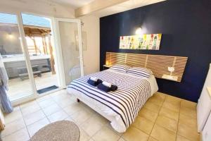 Schlafzimmer mit einem Bett mit blauer Wand in der Unterkunft La villa Ty Mor Braz in Plouarzel