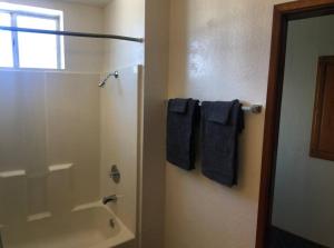 a bathroom with a shower and blue towels at Convenient 2BR Walk To Bart 10 Min To Berkeley in Richmond