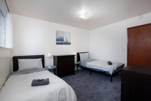 a bedroom with two beds and a table and a bedskirts at Convenient 2BR Walk To Bart 10 Min To Berkeley in Richmond