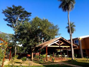 dom z dachem krytym strzechą i palmą w obiekcie ZenGarden Paraguay - Modernes und komfortables Haus Orchidee w mieście San Lorenzo de la Frontera