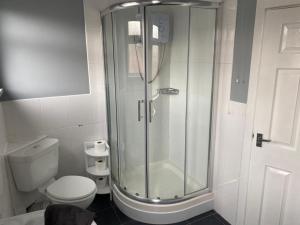 a bathroom with a shower and a toilet at Cheerful 3 bedroom Townhouse in Leeds