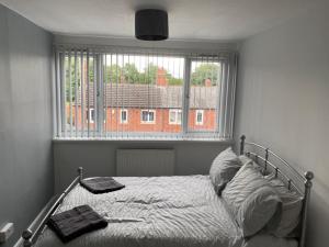 a bedroom with a bed and a large window at Cheerful 3 bedroom Townhouse in Leeds
