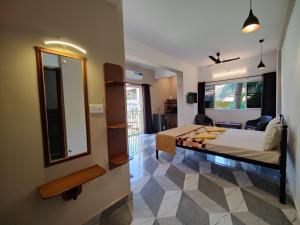a bedroom with a bed and a large mirror at Rosean Homestay Self Service Apartments in Candolim