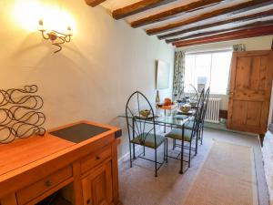 a dining room with a glass table and chairs at Lavender Cottage, Aldeburgh in Aldeburgh