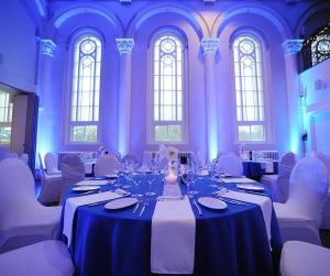 a large room with tables and white chairs and windows at Hotel Montfort Nicolet in Nicolet