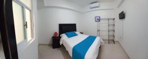 een slaapkamer met een bed in een witte kamer bij Hotel boutique turquesa in Tapachula