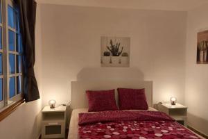 um quarto com uma cama com duas almofadas vermelhas em Casa Amanecer em Abades