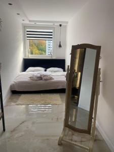 a mirror in a bedroom with a bed and a window at Apartament z balkonem i widokiem na morze w Sopocie blisko Opery Leśnej in Sopot