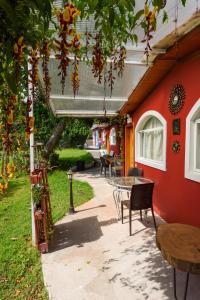 un patio con mesa y sillas junto a una pared roja en Casa Elalu, en Quito