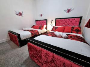 duas camas num quarto com vermelho e branco em *6B7R* Setup for your most relaxed & amazing stay + Free Parking + Free Fast WiFi* em Morley