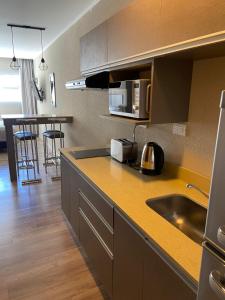 a kitchen with a sink and a counter top at Casa De Playa Dpto Con Pileta Climatizada A 50 M Del Mar in Necochea