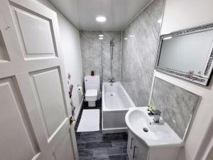 uma casa de banho com um lavatório, uma banheira e um WC. em *6B7R* Setup for your most relaxed & amazing stay + Free Parking + Free Fast WiFi* em Morley