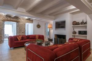 sala de estar con sofá rojo y mesa en La Vila d'Argençola - Apartamentos, en Castellnou de Bages