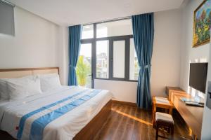 a bedroom with a bed and a large window at Santini Hotel in Tuy Hoa