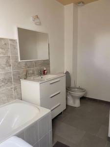 ein Badezimmer mit einem weißen Waschbecken und einem WC in der Unterkunft Maison Mitoyenne avec cour + parking in Sainte-Savine