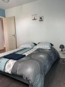 sypialnia z łóżkiem i narzutą na nie w obiekcie Maison Mitoyenne avec cour + parking w mieście Sainte-Savine