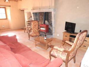 un salon avec un canapé et une cheminée dans l'établissement Maison charmante près de Nueil-les-Aubiers avec jardin, à Nueil-sous-les-Aubiers