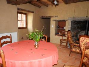une pièce avec une table avec un vase de fleurs dessus dans l'établissement Maison charmante près de Nueil-les-Aubiers avec jardin, à Nueil-sous-les-Aubiers 6 autres photos