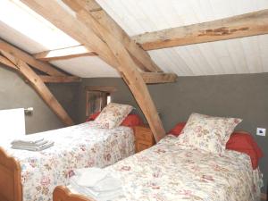 Duas camas num quarto com vigas de madeira em Propriete de 3 chambres avec jardin amenage et wifi a Nueil les Aubiers em Nueil-sous-les-Aubiers