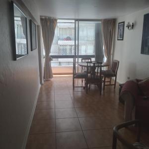 a living room with a table and chairs and a window at Katia in Santiago