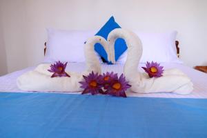 2 cygnes faits de serviettes sur un lit dans l'établissement Blue Waves Madiha, à Matara