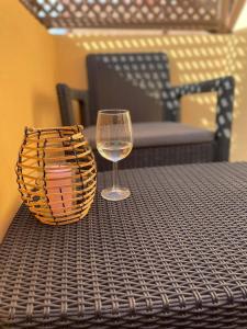 um copo de vinho sentado numa mesa com um cesto em Apartament Maia Ocean em Corralejo