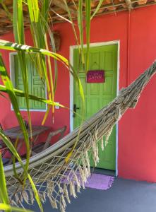 una hamaca frente a un edificio con una puerta verde en OCA Caraíva en Caraíva
