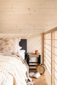 ein Schlafzimmer mit einem Bett und einer Holzwand in der Unterkunft Wy_spa_Podolany in Gdów