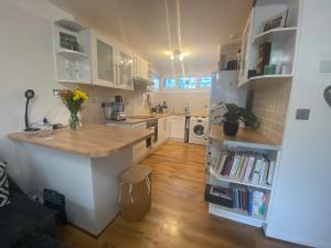 a kitchen with white cabinets and a wooden floor at Hidden gem in Central London Oval - Elephant and Castle in London