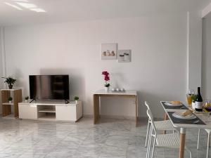 a living room with a television and a table with chairs at El Olivo House A in San Isidro