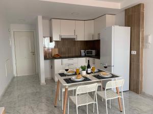 a kitchen with a table with chairs and a white refrigerator at El Olivo House A in San Isidro
